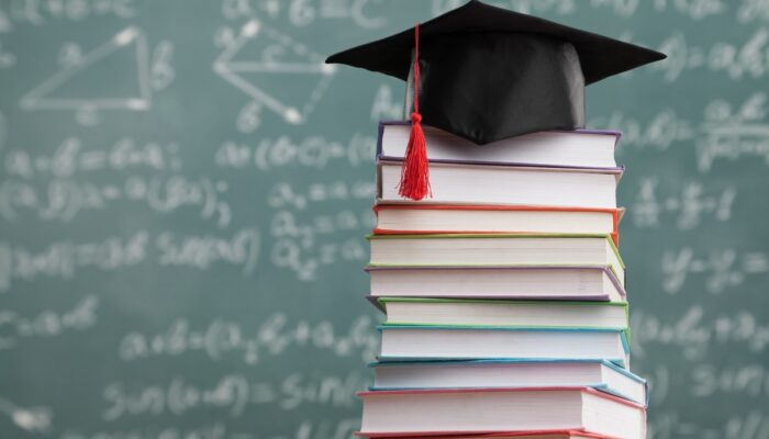 Książki i czapka absolwenta uczelni