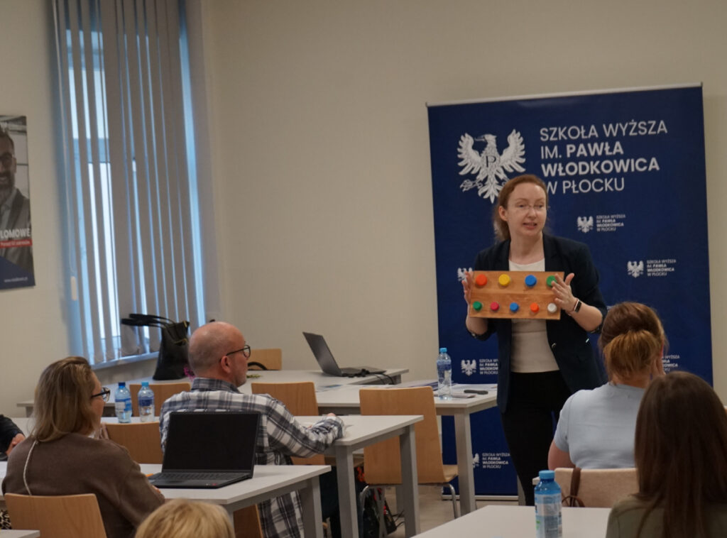 Prowadząca prezentuje własnoręcznie wykonaną zabawkę sensoryczną