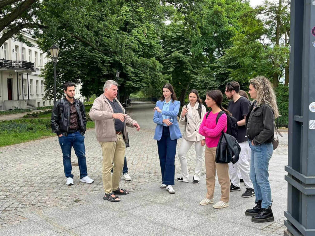 Prowadzący dyskutuje ze studentami w trakcie wycieczki