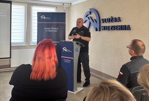 Przedstawiciel służby więziennej wita zgromadzonych gości